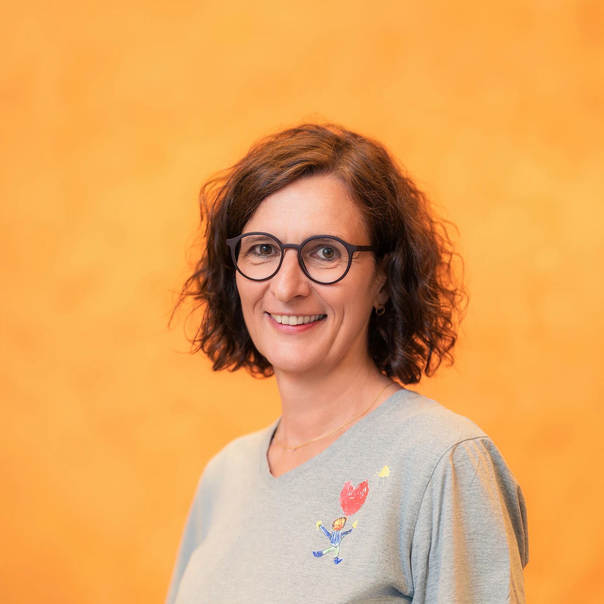 Porträt der Kinderkardiologin Dr. Sabine Born vor orangem Hintergrund