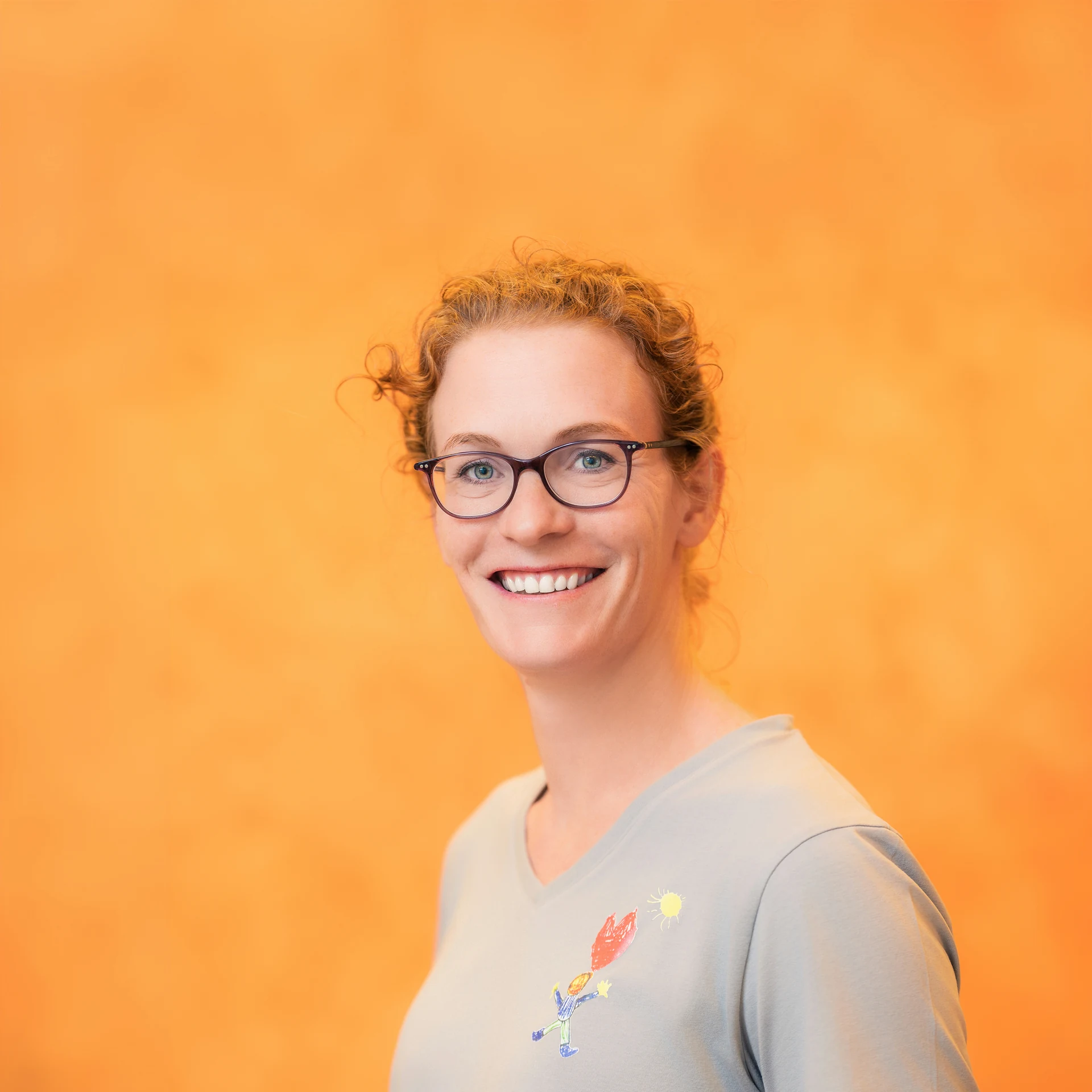 Porträt der Kinderkardiologin Dr. Julia Winter vor orangem Hintergrund