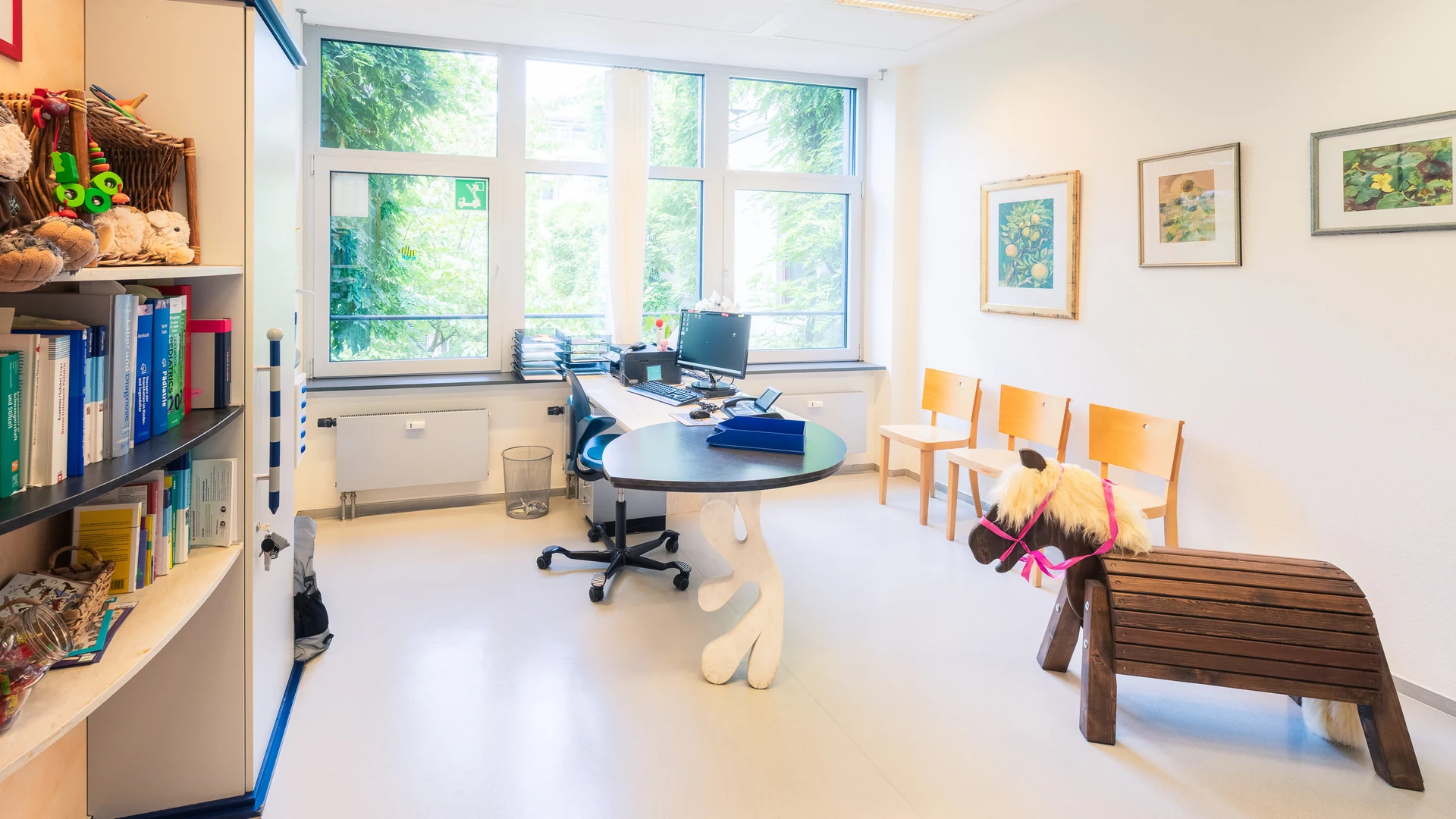 Sprechzimmer von Dr. Winter mit Schreibtisch, Bücherregal und hölzernem Pferd