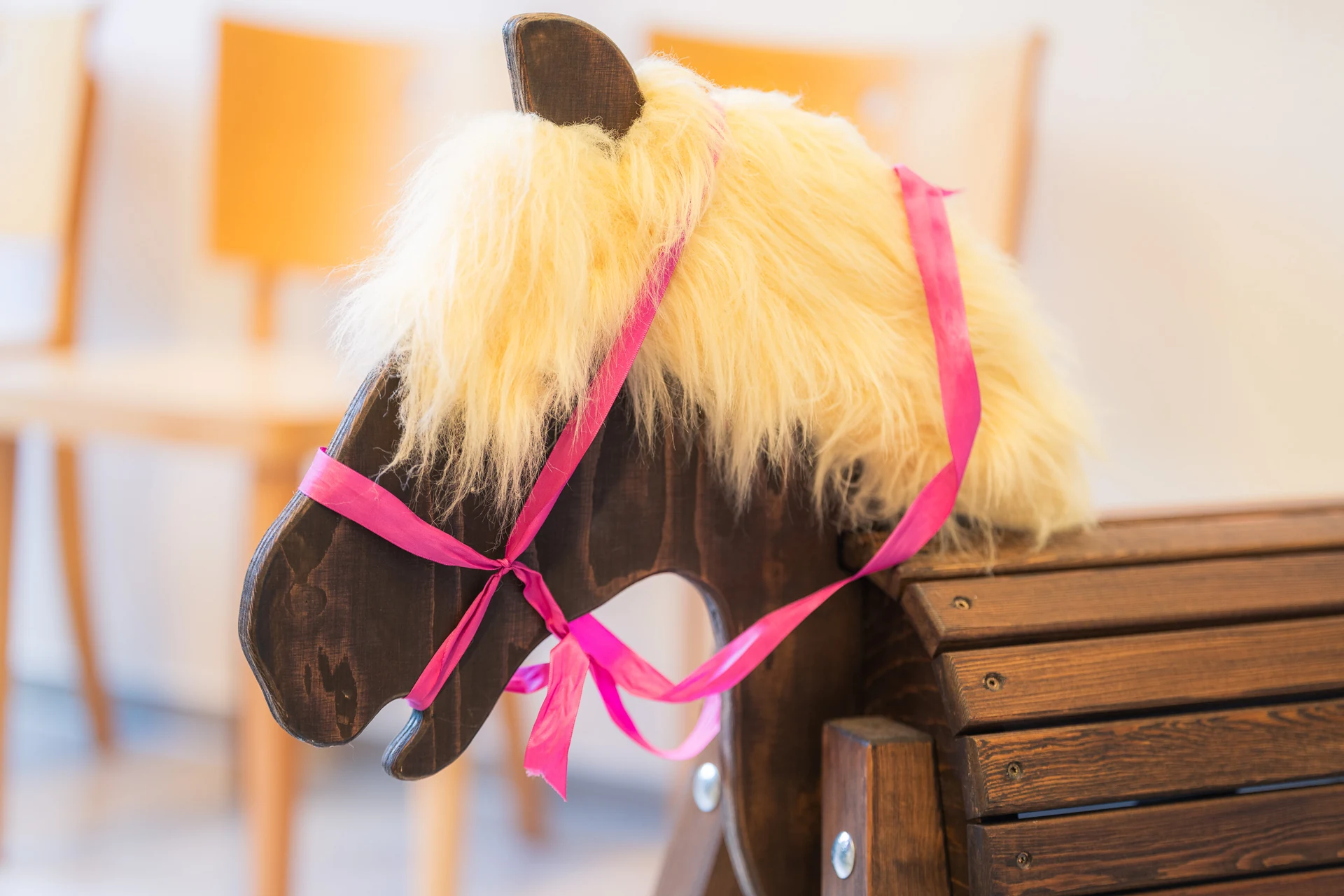 Holzschaukelpferd mit blonder Mähne und rosa Schleife im Wartezimmer der Kinderkardiologie