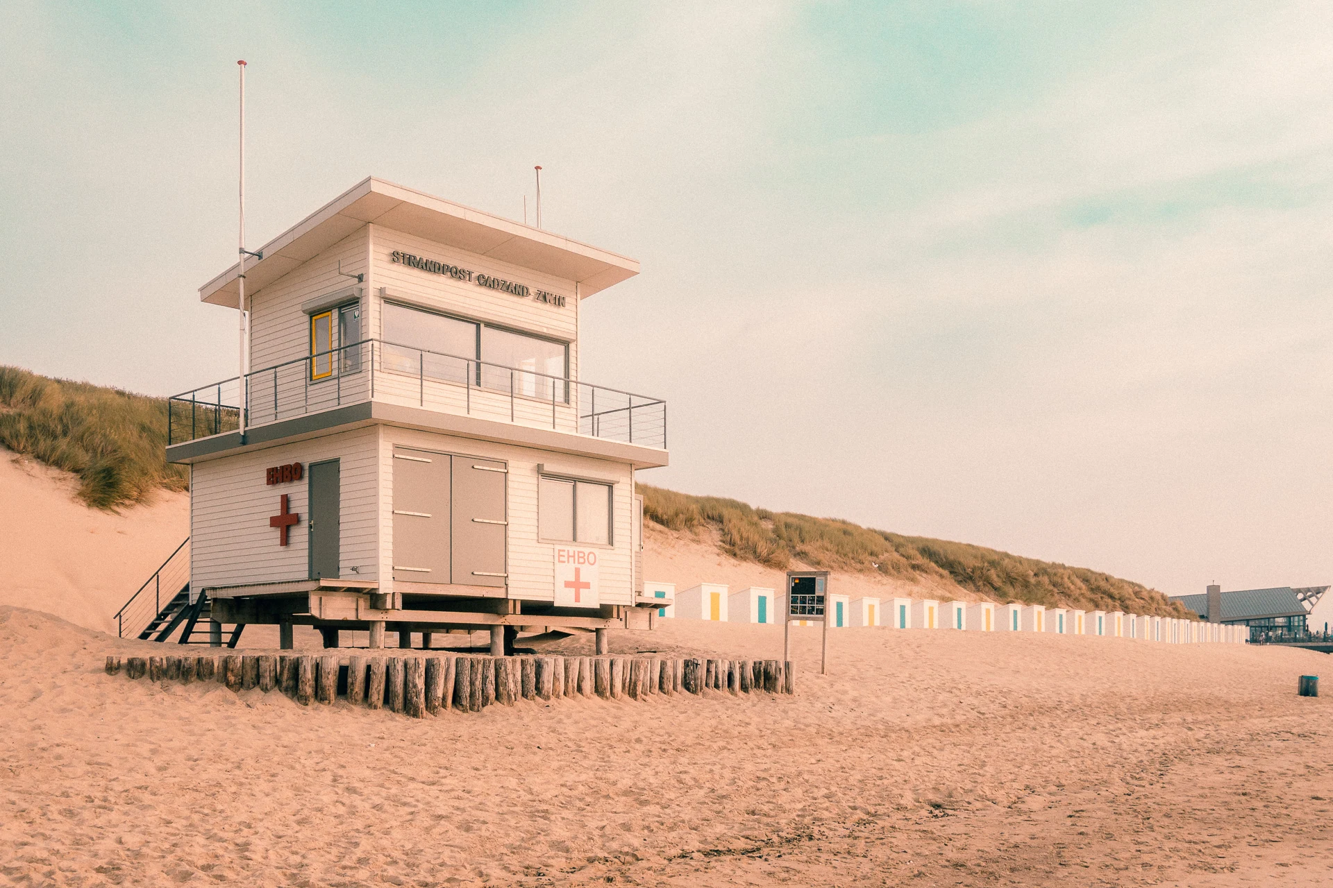 Rettungsstation auf Stelzen am Strand von Cadzand, dahinter Strandhäuschen