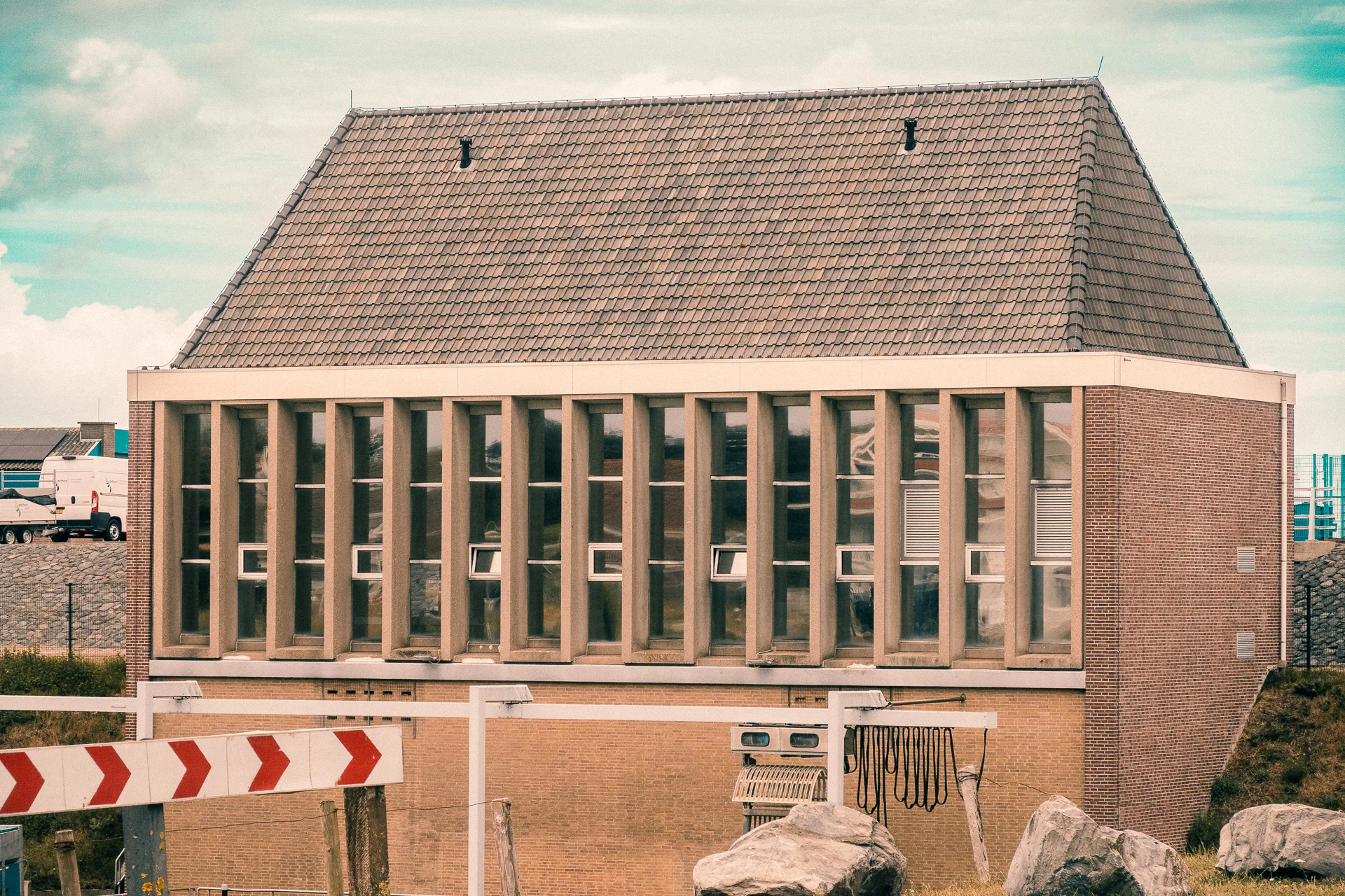 Backsteingebäude mit großen Fenstern hinter einer Absperrung