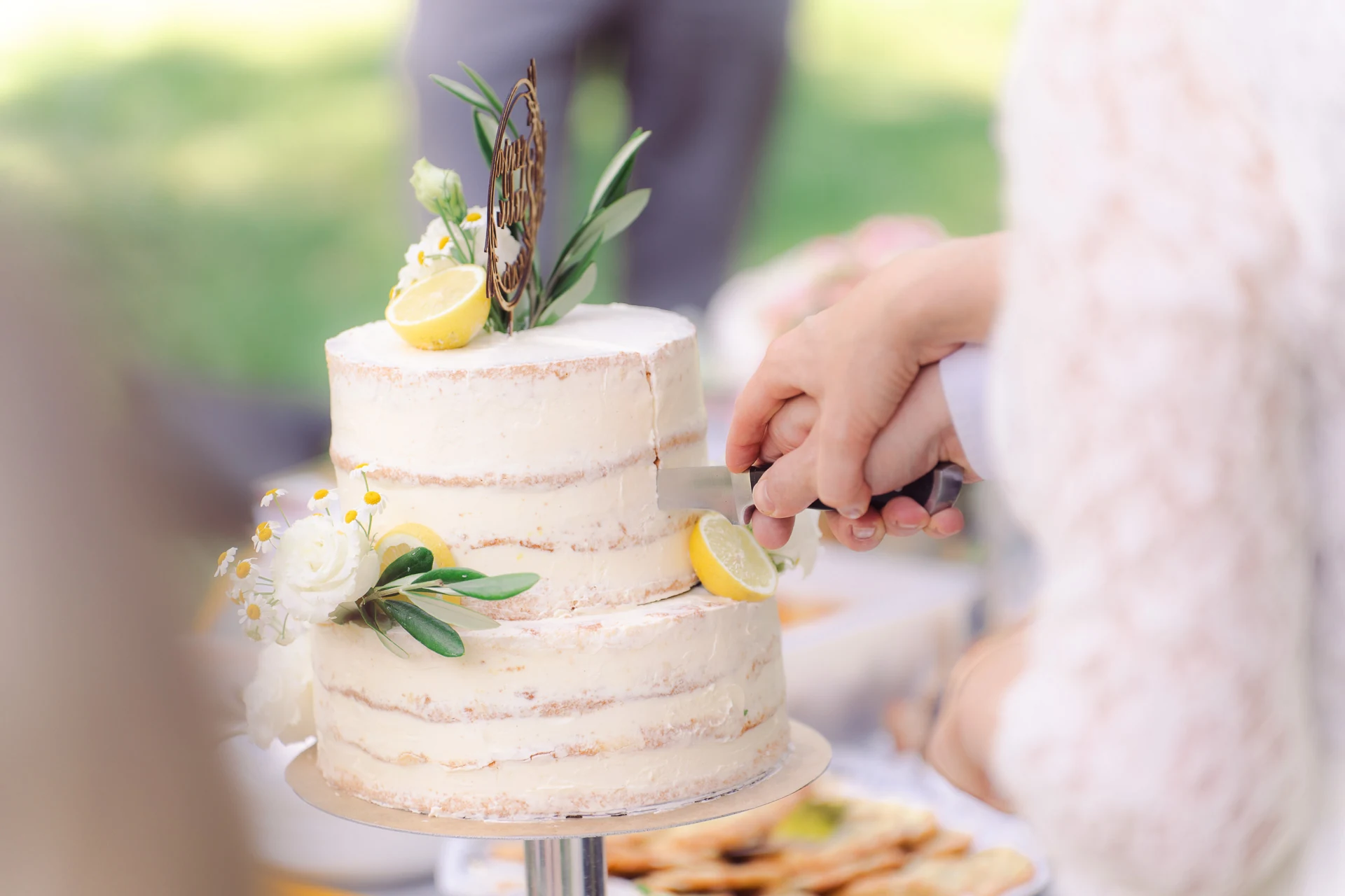 Das Brautpaar schneidet die Hochzeitstorte mit Zitronen an