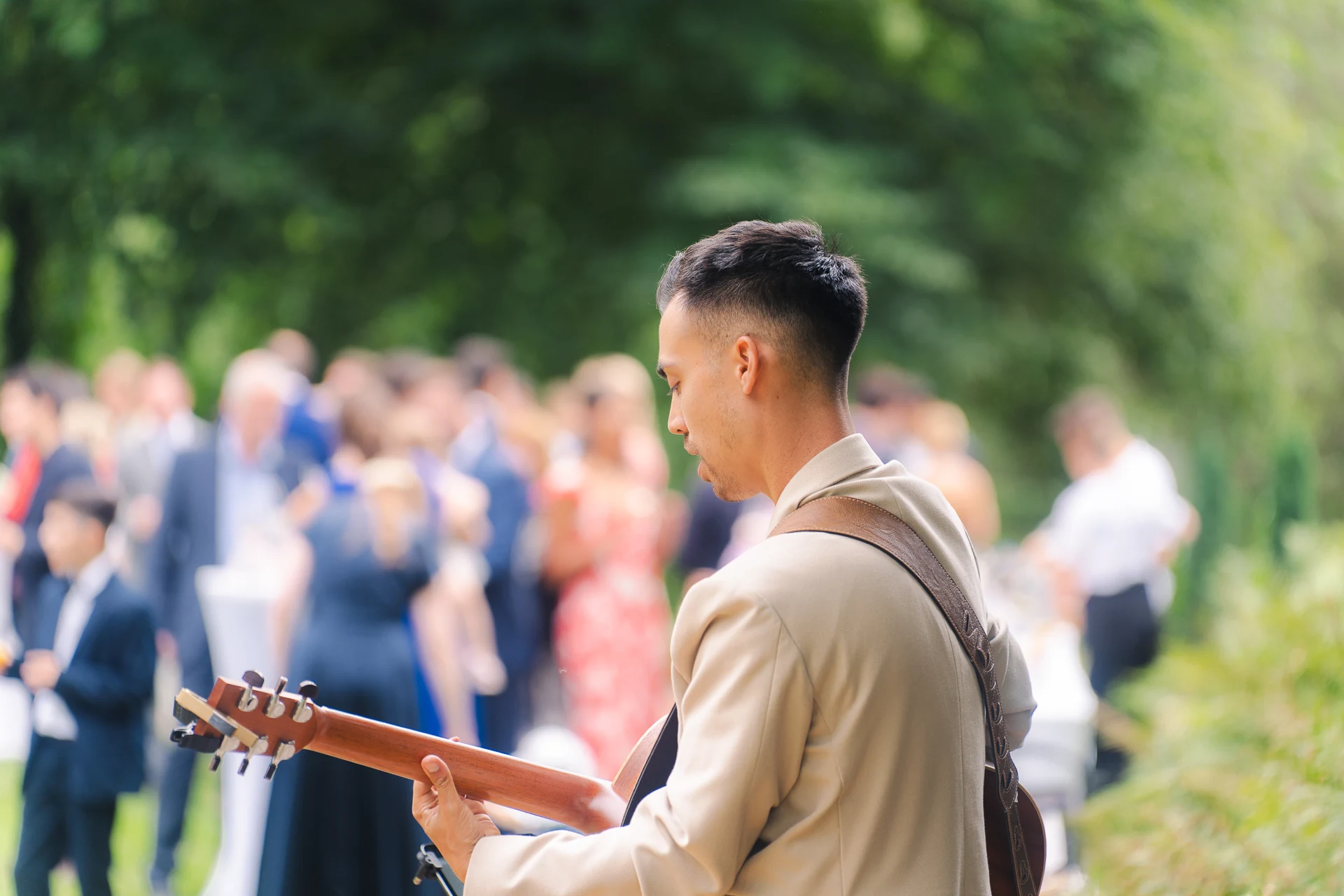 Gitarrist spielt beim Empfang im Schlosspark, dahinter die Gäste